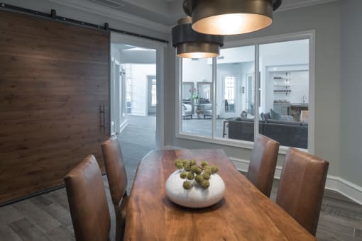 A wooden dining table with a bowl of grapes on top and brown chairs at McDermott Place, Plano, TX