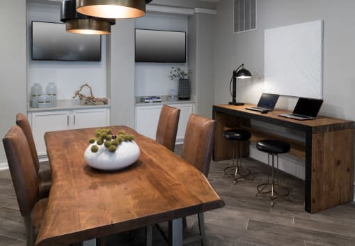 a dining room with a table and chairs and a desk with a laptop at McDermott Place, Plano