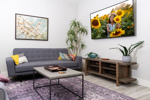 mihir taylor model living room with a couch and a table and a picture of sunflowers