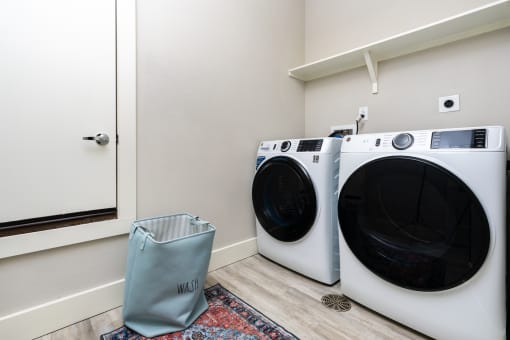 a washer and dryer in a laundry room with a mirror and a door