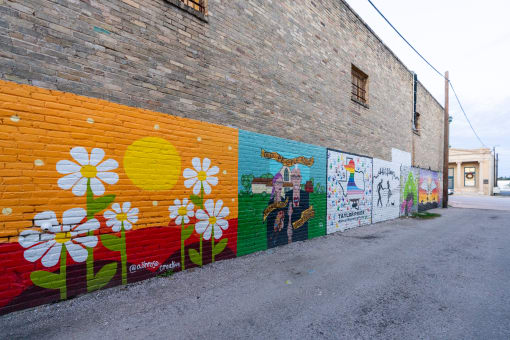 a mural on the side of a brick wall with flowers