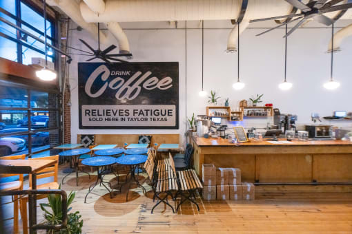 a coffee shop with blue tables and a sign that reads coffee reduces fatigue