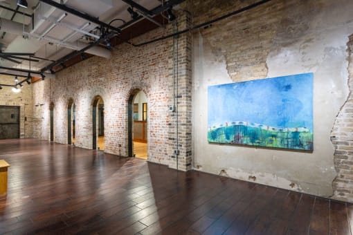 a large room with wood floors and a painting on the wall