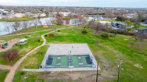 an aerial view of a basketball court on top of a green field