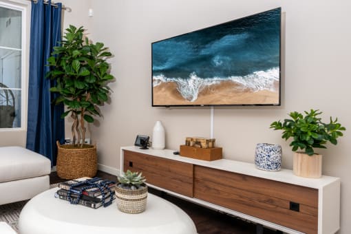 a living room with a tv on the wall and a table with plants at Miro at the Parc, Henderson