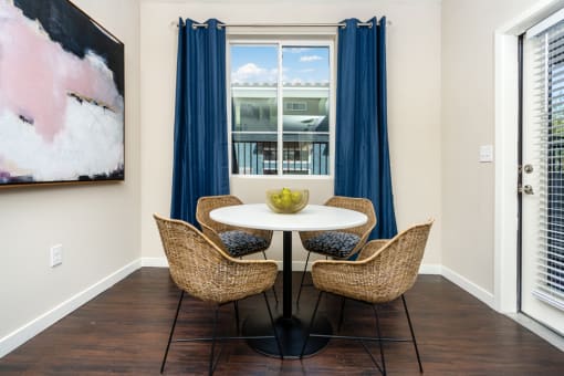 a dining area with a table and chairs and a window at Miro at the Parc, Henderson, Nevada