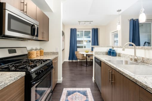a kitchen with stainless steel appliances and granite counter tops at Miro at the Parc, Henderson