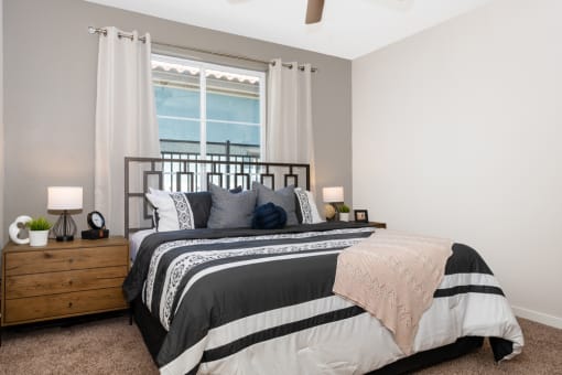 an empty bedroom with a bed and a window at Miro at the Parc, Henderson, NV