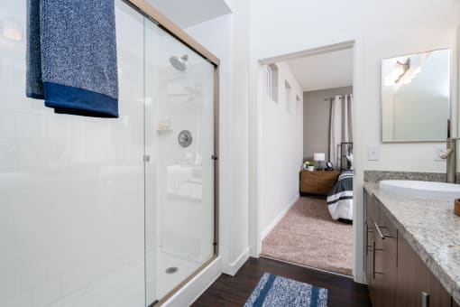 a bathroom with a shower and a bedroom with a bed at Miro at the Parc, Henderson, NV 89074