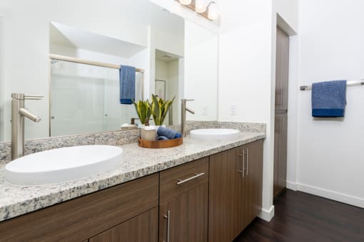 a bathroom with two sinks and a large mirror at Miro at the Parc, Henderson, NV