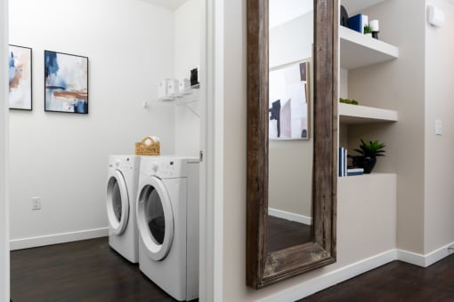 a small laundry room with a washing machine and a mirror at Miro at the Parc, Henderson, 89074