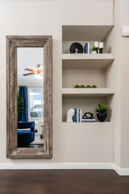 a mirror hanging on a wall in a living room at Miro at the Parc, Henderson, NV 89074