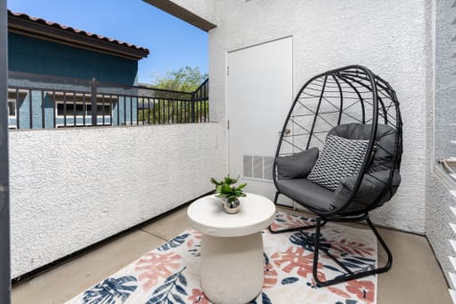 a balcony with a chair and a table and a door at Miro at the Parc, Henderson
