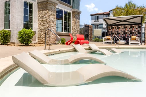 commons pool and hot tub with chairs and a building at Miro at the Parc, Henderson, Nevada