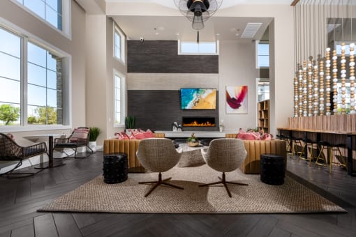 a living room with a fireplace and a table and chairs at Miro at the Parc, Henderson, NV