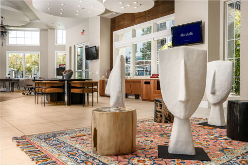 the lobby of a building with sculptures and a table and chairs at Miro at the Parc, Henderson, NV 89074