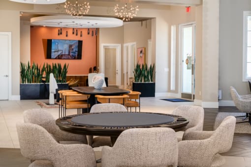 a living room with tables and chairs and a television at Miro at the Parc, Henderson, 89074
