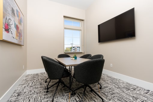 a conference room with a table and chairs and a television at Miro at the Parc, Henderson, Nevada