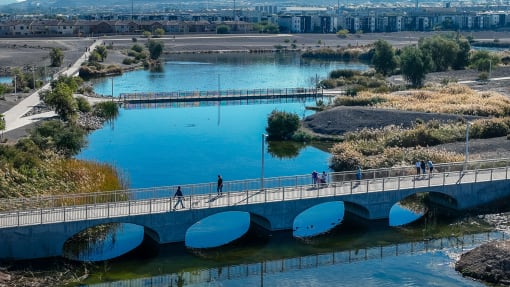 people walking across a bridge over a river at Miro at the Parc, Nevada 89074