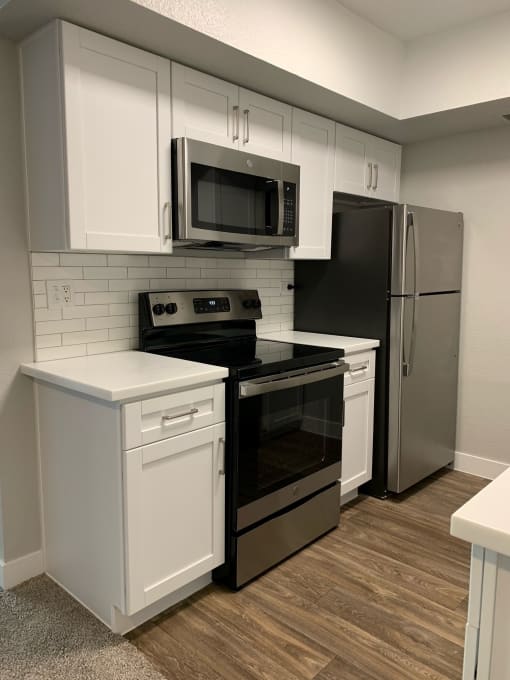 a kitchen with stainless steel appliances and white cabinets at Monaco at McCormick Ranch, Scottsdale, AZ