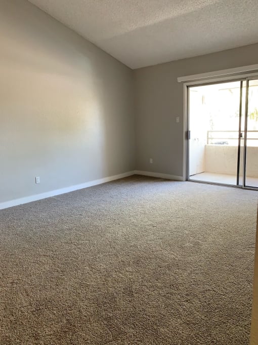 an empty living room with a sliding glass door at Monaco at McCormick Ranch, Scottsdale, AZ 85258