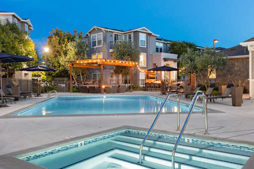 A pool with a slide and a building behind it.