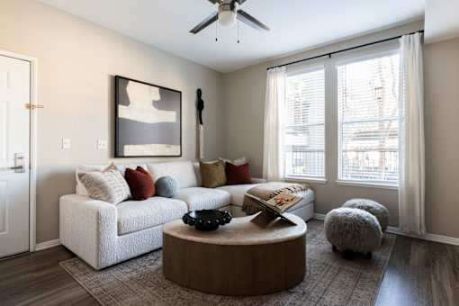 A living room with a white couch, a coffee table, and a ceiling fan.