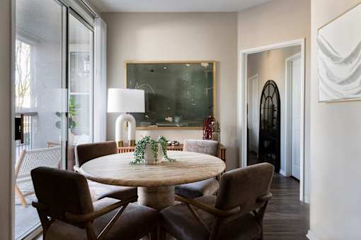 A dining room with a round table and chairs.