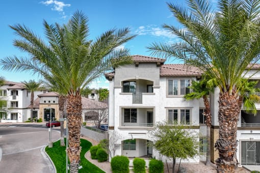 an apartment building with palm trees in front of it