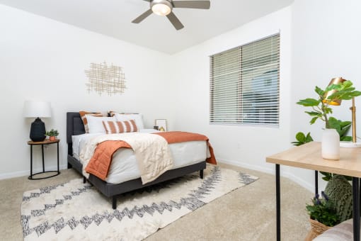 a bedroom with a bed and a ceiling fan
