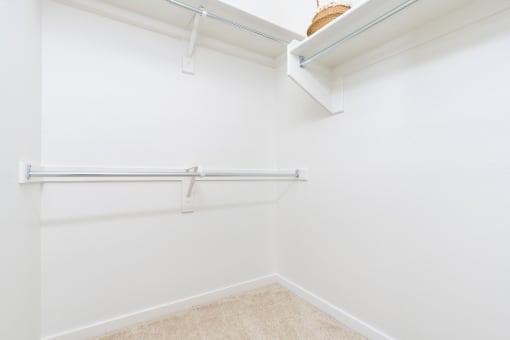 a white closet with a shelf and a hanging rail on the wall