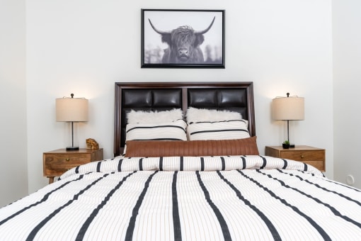 a bedroom with a bed and a picture of a bull on the wall