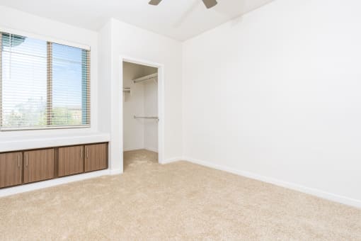 an empty room with a large window and a closet