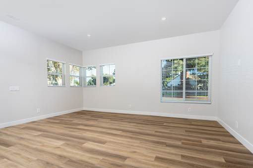 A room with wooden flooring and two windows with blinds. at Nola 624, West Covina, CA