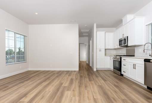 A kitchen with white cabinets and a wooden floor. at Nola 624, California