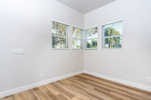 A room with wooden floors and two windows with blinds. at Nola 624, West Covina, CA 91790  