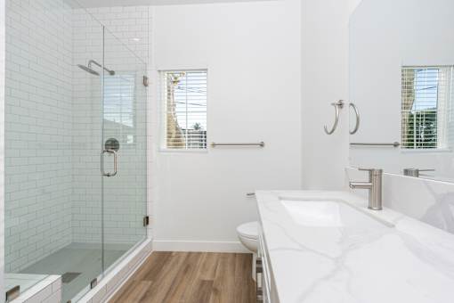 A white bathroom with a walk-in shower and a large sink. at Nola 624, West Covina, 91790  