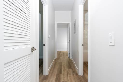 A long hallway with white walls and wood floors. at Nola 624, West Covina, CA 91790
