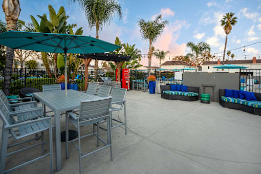 A patio with a table and chairs under a green umbrella. at Nola 624, West Covina California