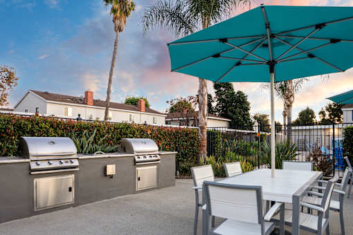 A patio with a table, chairs and a grill. at Nola 624, California