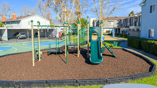 A playground with a green slide and a red swing set. at Nola 624, West Covina, CA 91790