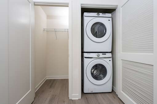 A white washing machine is in a small laundry room.