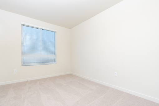 A room with a window covered by blinds.