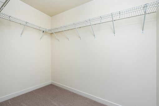 Empty room with a white wall and a metal rack on the wall.