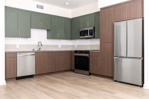 A kitchen with a refrigerator, oven, and microwave.