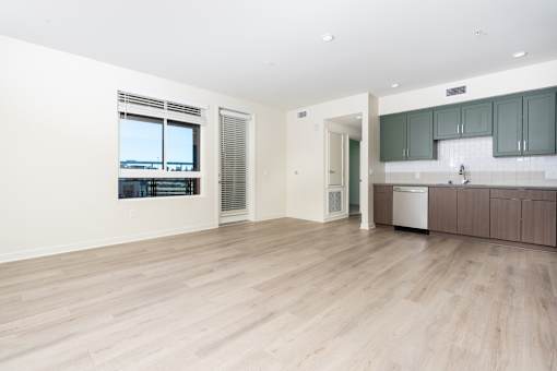A kitchen area with a dishwasher and a window overlooking a body of water.