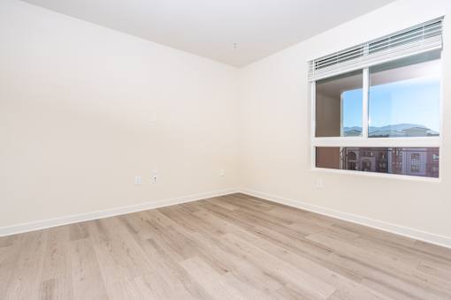 A room with a window and wooden flooring.