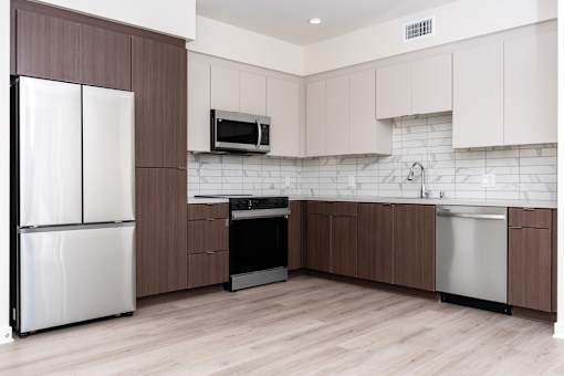 A kitchen with white appliances and brown cabinets.