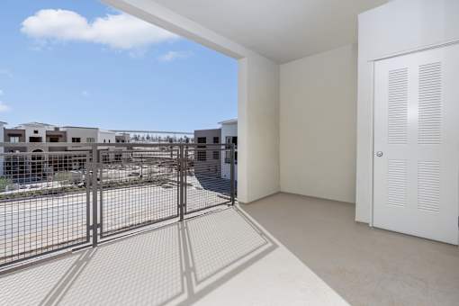A white room with a view of a construction site through a window.