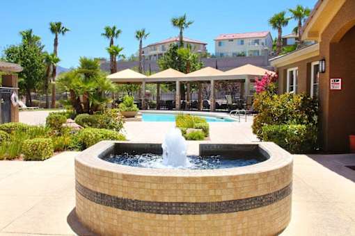 A fountain in the middle of a pool surrounded by a brick wall at Avalon at Seven Hills Apartments, Henderson, 91790